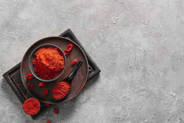Bowls and spoon with red chili powder on grey background - Powered by Adobe