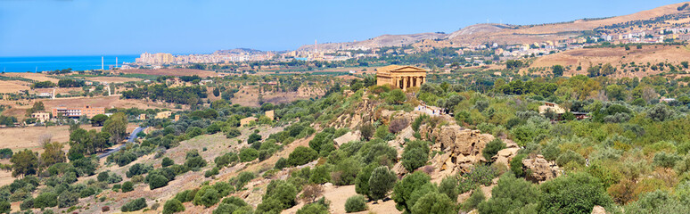 Fototapeta na wymiar Aerial bird view, Valley of of Temples, Agrigento, Sicily, Italy, with Temple of Concordia in the middle. Summer sunny day, blue sky, panoramic banner image.