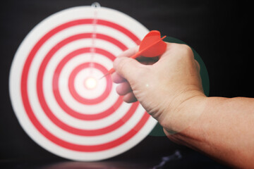 hand holding dart board with target