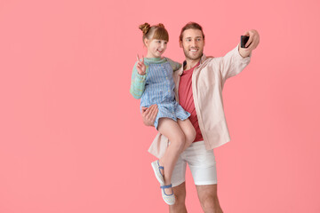Happy father and daughter taking selfie on color background