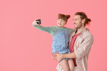 Happy father and daughter taking selfie on color background