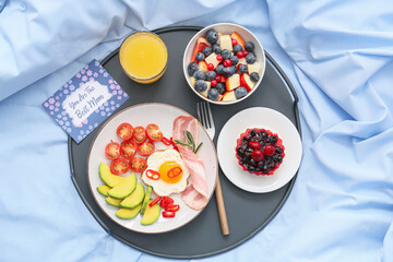 Tasty breakfast for mother on bed