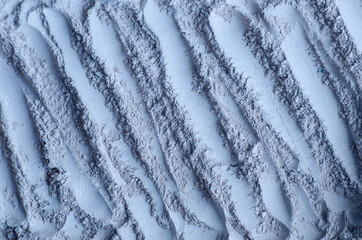 Light blue bentonite clay powder (alginate, facial mask, eye shadow, body wrap) texture close up, selective focus. Abstract background.