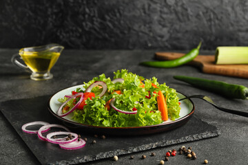 Plate of fresh salad with vegetables on dark background