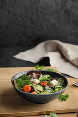 Bowl of fresh salad with vegetables on dark background