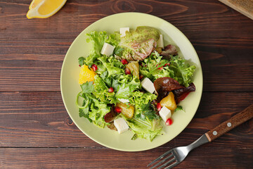 Plate of fresh salad with vegetables on wooden background