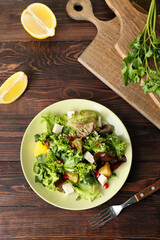 Plate of fresh salad with vegetables on wooden background