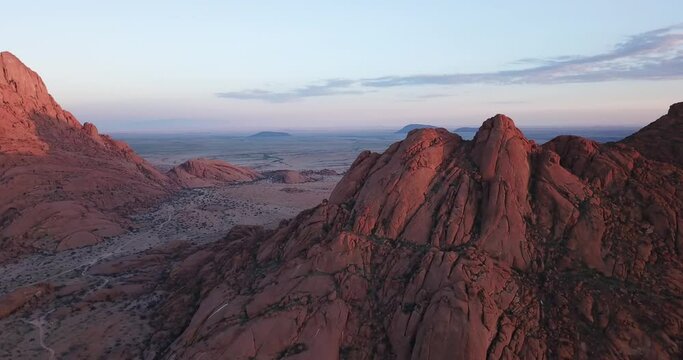 4K sunrise aerial footage of savanna, famous red granite Spitzkoppe Peak and Pontok Mountains in central Namibia between interior town Usakos and Atlantic west coast, southern Africa