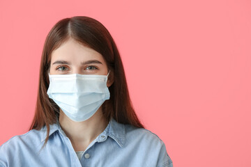 Young woman in medical mask on color background