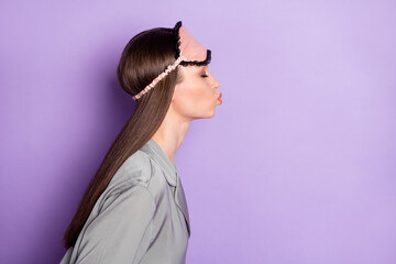 Profile side view portrait of attractive dreamy girl wear pajama sending air kiss amour copy space isolated over violet purple color background