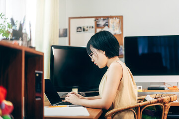 Young adult asian woman stay and working  from home office use laptop for internet online. - obrazy, fototapety, plakaty