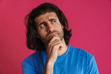 Puzzled brunette man in t-shirt think and looking upward