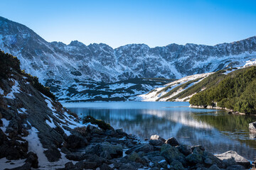 Dolina Pięciu Stawów Polskich in Tatra National Park, Poland. Wintery aura in the mountains. Sunny day, cold lake water, fresh snow. Selective focus on the rocks, blurred background. © juste.dcv