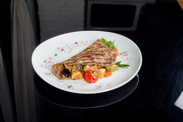 Grilled beefsteak served with potatoes and onions