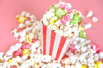  popcorn spilling from a container on red background 