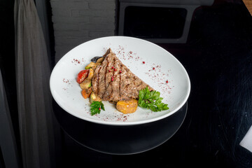 Grilled beefsteak served with potatoes and onions