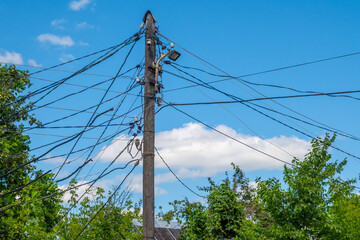 An old wooden electric pole with many wires