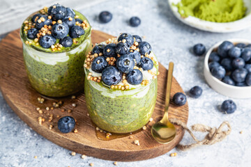 Overnight matcha chia oats are topped with yogurt and blueberries.