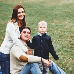 boy and mother hugging father during stroll in autumn park