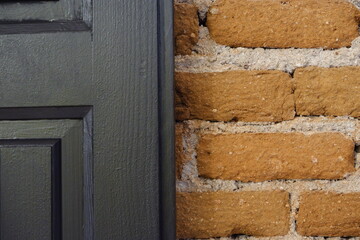 Black wooden door with bricks