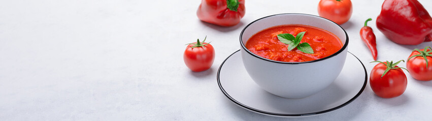 Bowl of gazpacho soup and fresh tomatoes with bell peppers and chili peppers banner with copy space
