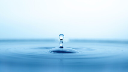 Fototapeta na wymiar water drop splash in a glass blue colored