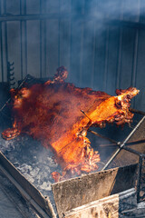 A whole crispy pork grilled on hot coals