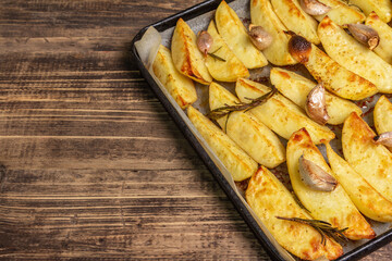 Baked pieces of spiced potato in a baking pan