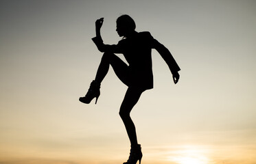 Fototapeta na wymiar female silhouette on sunset sky background of dancing woman, silhouette