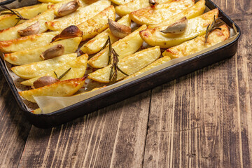 Baked pieces of spiced potato in a baking pan