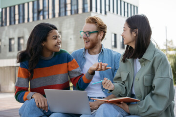 Group of multiracial university students  studying, education concept. Smiling business colleagues meeting, talking, discussing start up project, working together, selective focus  