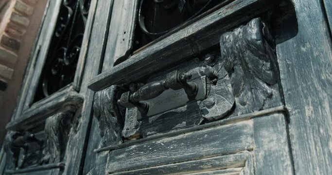 Tilt shot of old vintage rusty wooden door with iron handles. 