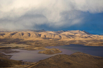A dramatic landscape overlooking the altiplano in Peru at sunset. Mountains, hills, lakes, lunar...