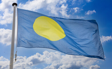 Palau flag waving against blue cloudy sky