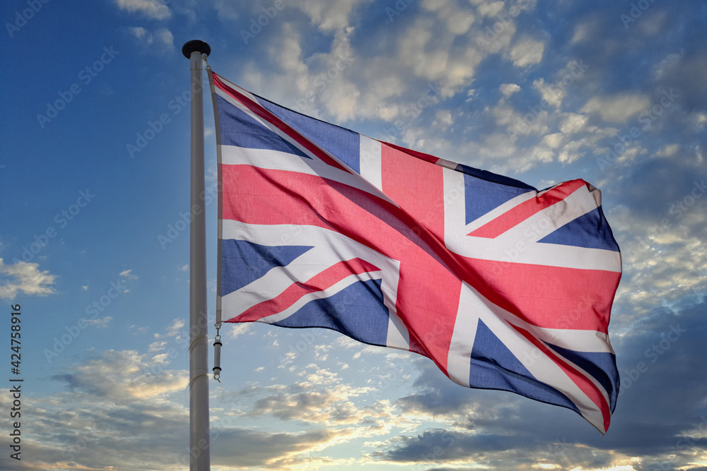 Sticker United Kingdom flag waving against blue cloudy sky