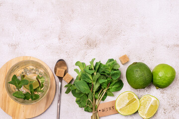 Ingredients for Making Mojitos Gass with Ice Cube Fresh Mint Leaves Sugar and Ripe Lime Cocktail Shaker on Concrete Background Top View Copy Space
