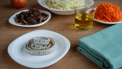 Healthy eating. Vegan food. Mushrooms, raw, chopped vegetables for salad on white plates. Cabbage, carrots, onions. Olive oil.