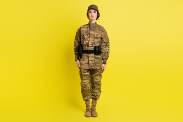 Full size portrait of calm concentrated girl standing look camera isolated on vibrant yellow color...