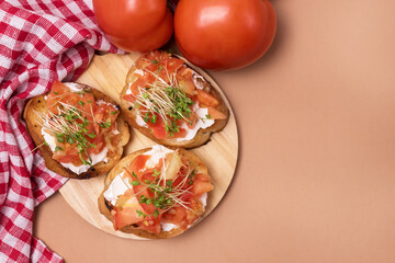 Bruschetta with Tomatoes Cheese and Herbs on Toasted Garlic Cheese Bread on Wooden Tray Orange Background