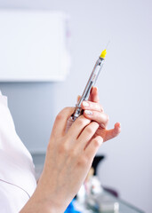 Female hands with a syringe for injection. Vaccination.
