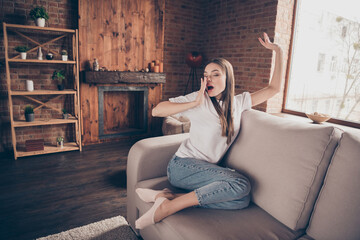 Photo of beautiful tired young lady wear white t-shirt sitting sofa yawning stretching closed eyes...