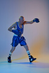 Fototapeta na wymiar Senior man wearing sportwear boxing isolated on gradient studio background in neon light. Concept of sport, activity, movement, wellbeing. Copyspace, ad.
