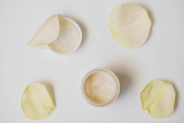 Bowl of cream wiht roses on white background, top view. image of homemade cosmetics ingredients. aroma theme. organic cosmetics.