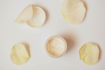 Bowl of cream wiht roses on white background, top view. image of homemade cosmetics ingredients. aroma theme. organic cosmetics.