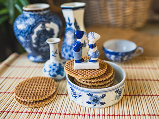 Traditional Dutch stroopwafel with syrup and typical Dutch blue. Porcelain figurines of kissing boy and girl in national Dutch costumes