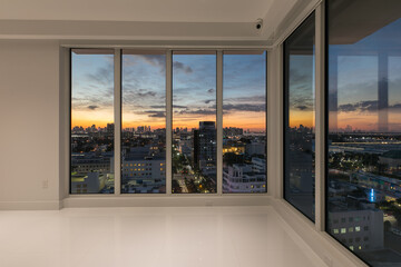 Interior Wall to Wall Window overlooking Sunset twilight cityscape Miami Florida