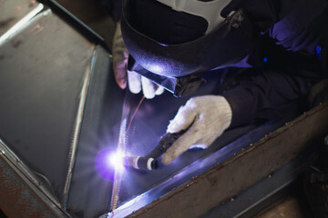 Welder is welding the steel in the factory. Weld the steel in dark.