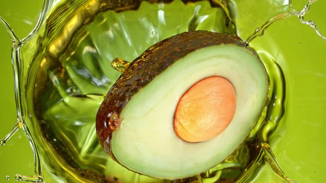 Super Slow Motion Shot of Fresh Avocado Falling and Splashing into Oil at 1000 fps.