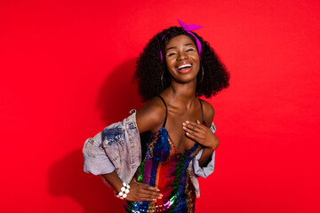 Photo of shiny funny wavy dark skin lady wear pin up outfit laughing arm waist closed eyes isolated red color background