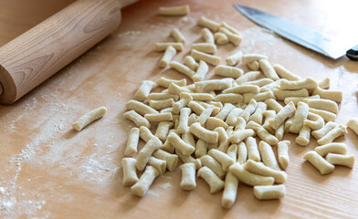 Raw dough or noodle pieces on wooden table